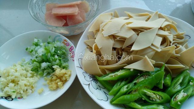 准备好材料，猪肉切片，葱姜蒜切末，干豆腐改刀切菱形块，尖椒切段。
