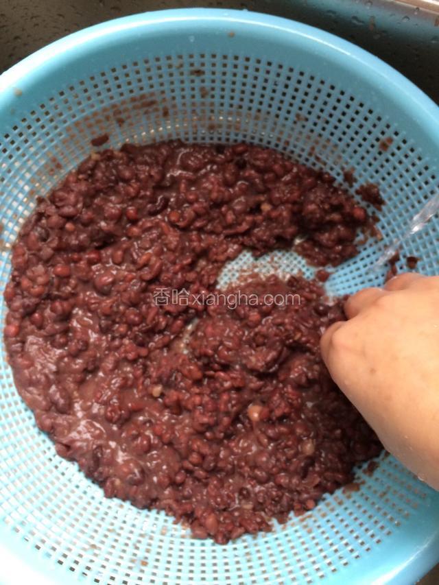 洗豆沙：捣烂的红豆连水倒进筛网比较小的篮子里，底下用盆装好。边用手搅拌，边用细小的自然水冲。把豆沙洗净。