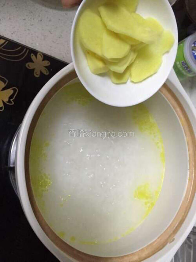 经过二十分钟的熬煮，粥汤变成奶白色，米粒略弯，这时加入姜片