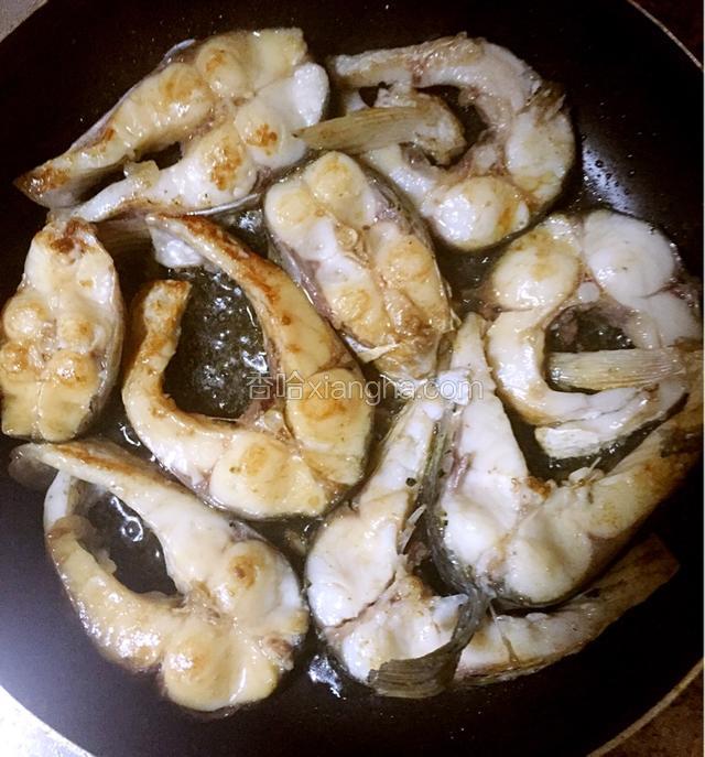 热锅冷油中火慢煎腌好鲩鱼，煎到微黄后捞出待用