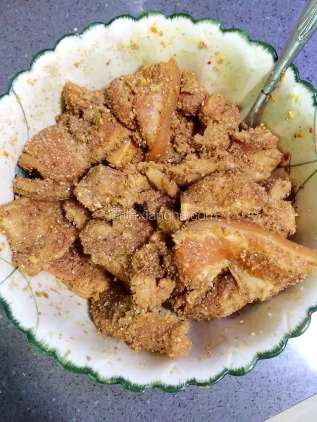 将腌制好的肉片，倒入米粉加少许清水搅拌均匀。