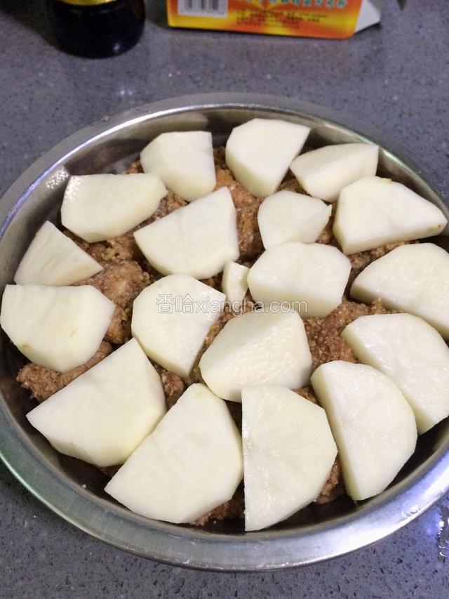 最后把土豆切块摆在肉片上面，锅底放入适量的水，再放入蒸格架，就可以入锅蒸了