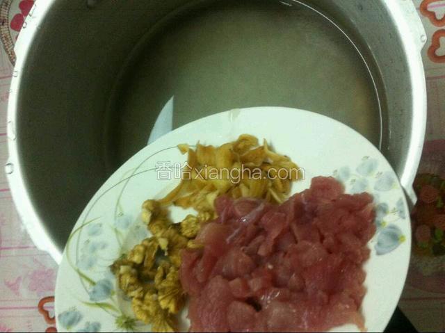 如图：取高压锅,将200ml大米洗干净，放入适量水，在放入切好的猪肉，核桃，百合