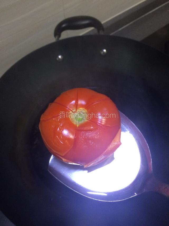 把西红柿放在沸水里，煮至皮爆开，捞出冲凉水撕去西红柿皮。