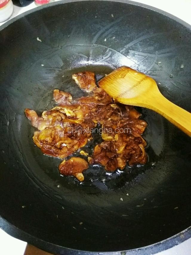 热锅冷油倒入腌好的肉，炒至变色