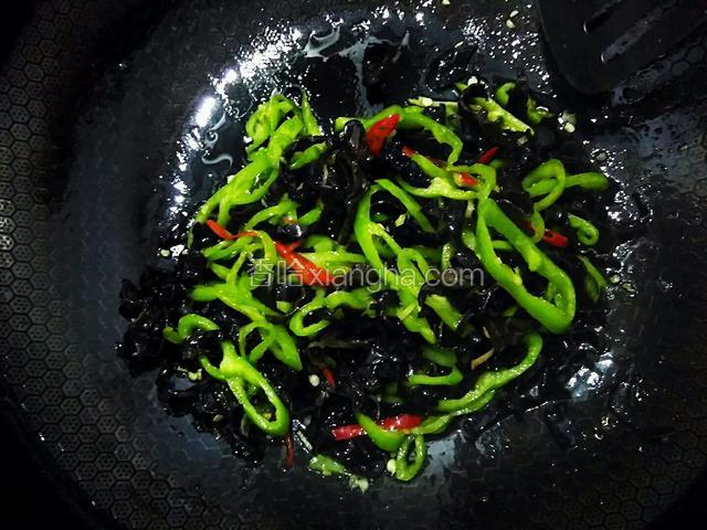 炒至木耳变色。加一勺料酒，一勺白糖，翻炒均匀。
