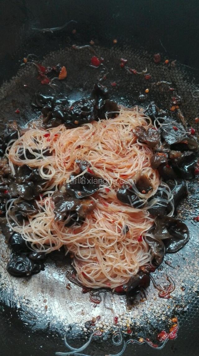 粉丝炒出淡黄色后，倒入调味汁，再次翻炒。