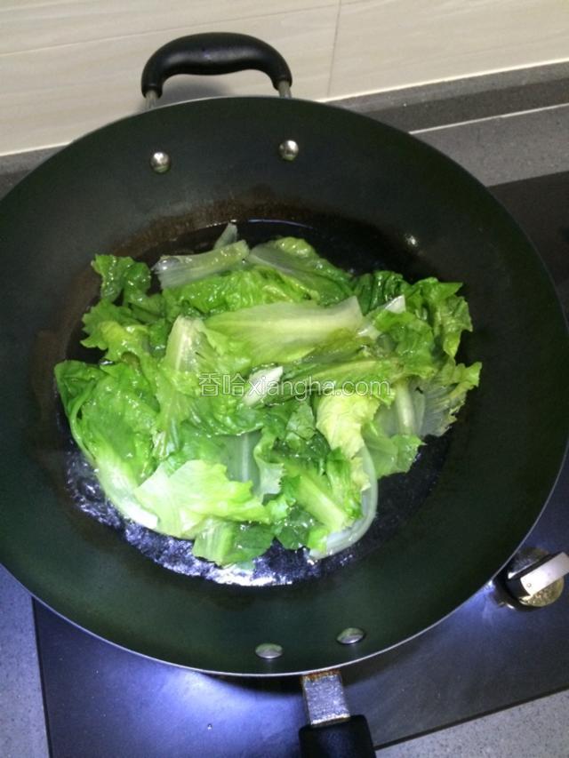 水开后，倒入生菜煮大约30秒，就是叶子变得翠绿的时候，捞出控水备用。