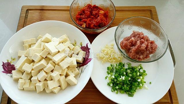 准备食材:豆腐切小块，猪肉剁成肉糜，辣白菜切小段，切葱花和蒜末。