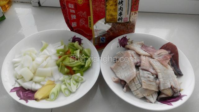 准备食材，鱿鱼切花刀，洋葱和尖椒切小块。