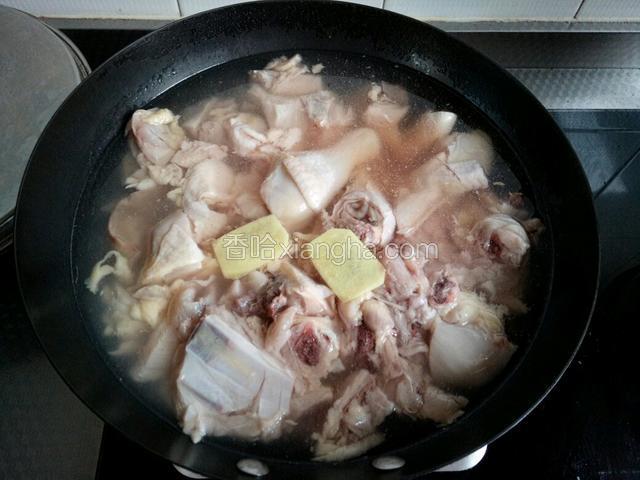 锅中放凉水，加料酒和两片姜片，同时下入鸡块，煮沸去血末