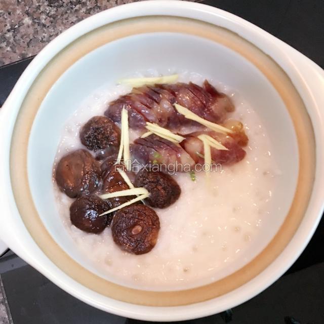 加入腊肠、香菇、姜丝，盖上盖，继续小火慢煲