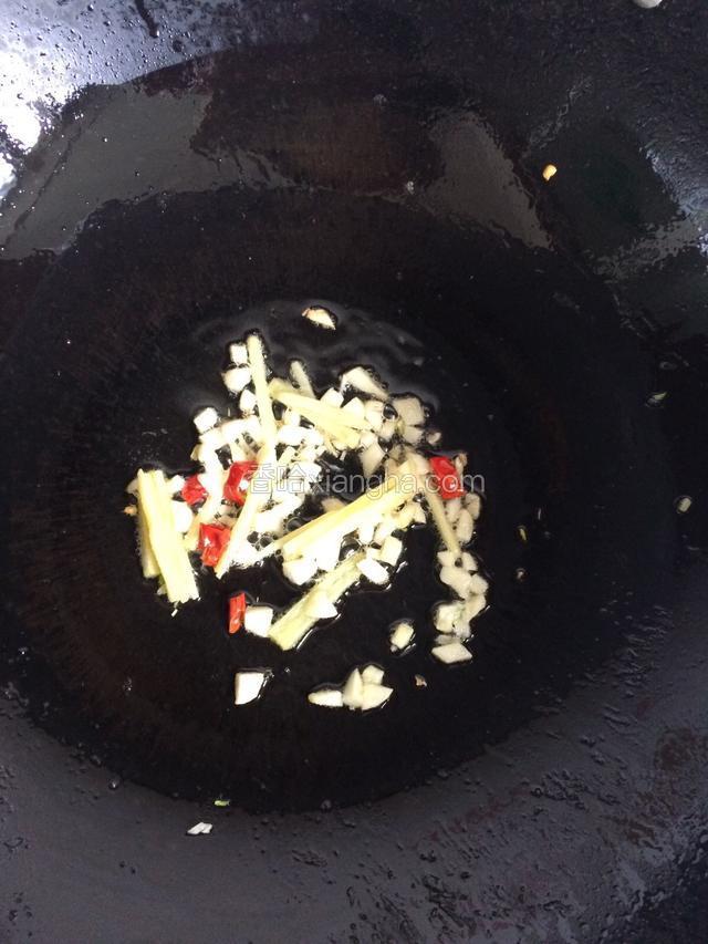 开小火放入姜丝、蒜粒、辣椒粒炒香。