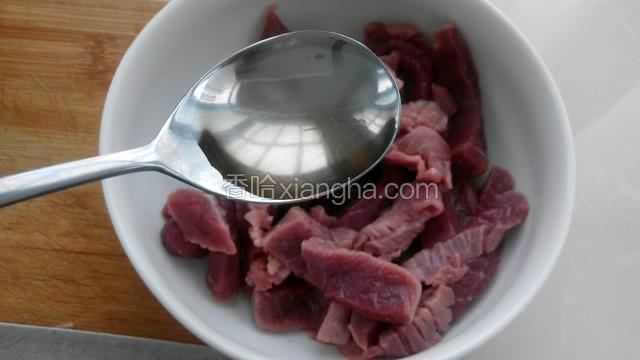 牛肉切条状，放入一勺料酒。