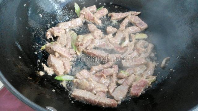 锅中放适量油烧温后放入葱花和姜片爆香，再把牛肉放进去翻炒三到五分钟至变色。