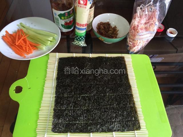 备好料，将海苔平铺到竹席上，将胡萝卜、黄瓜切成条。