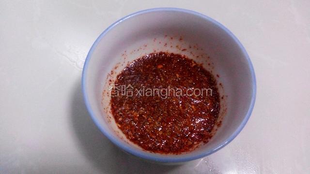 榨辣椒油:锅中放适量油烧热后浇入装有辣椒面和芝麻的小碗里。