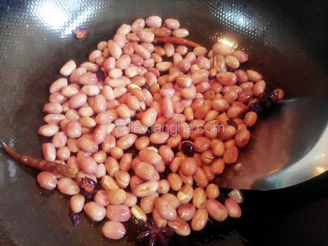 将火调制中小火，花生米倒入锅内不停地翻炒！