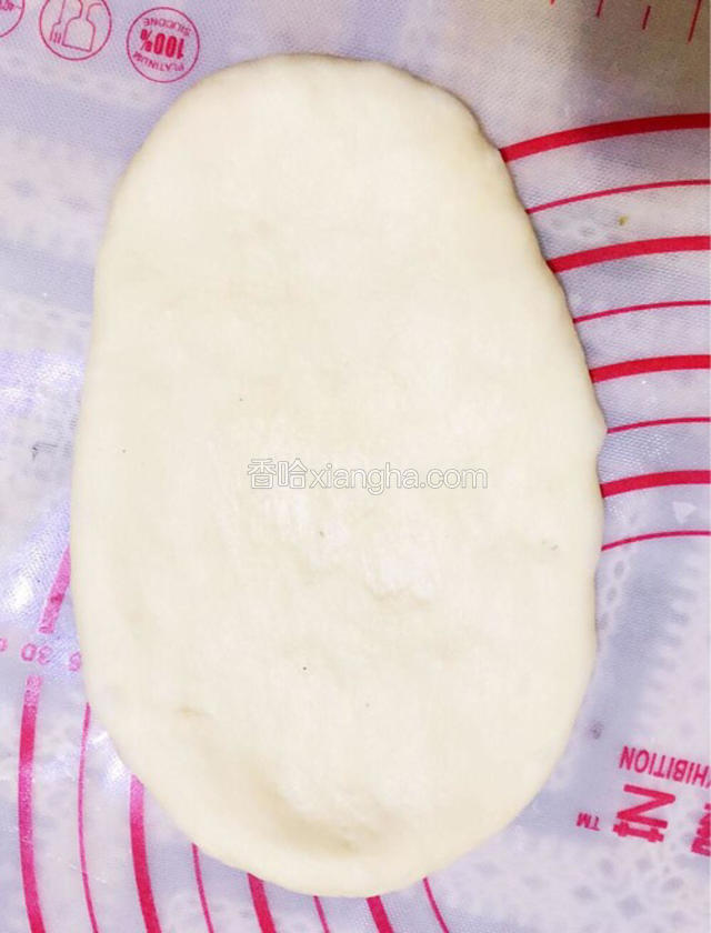 取一个面团按扁，擀成椭圆形面片；