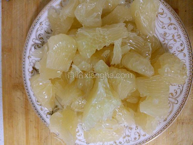 将柚子的果肉撕成碎片放入盘子中备用