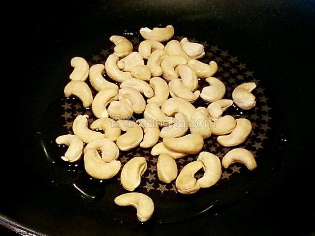 腰果放锅里，放入一半的油，开小火，让油温和腰果随着锅一起加热，一直搅动