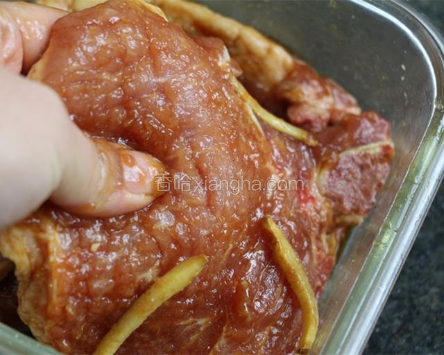 拍好的肉加入一茶匙盐、姜丝、一汤匙料酒、一汤匙生抽、半汤匙老抽、鸡蛋清抓匀，并用手按摩肉表面。