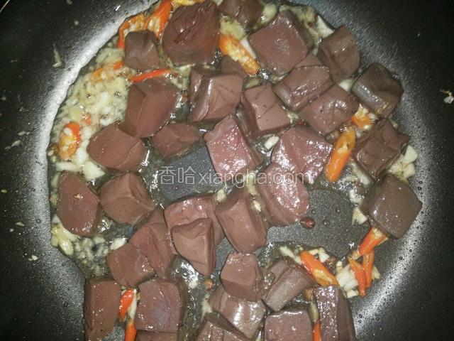 先下切好的血豆腐，晃锅，并烹入一勺料酒，继续晃锅