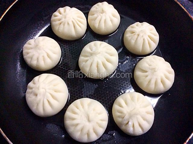 锅中放适量油，烧微热，把包子放入锅里用文火煎一下，底下有点微黄定型就可以加水了。