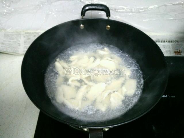 锅里水烧开，放入鸡肉片焯熟。