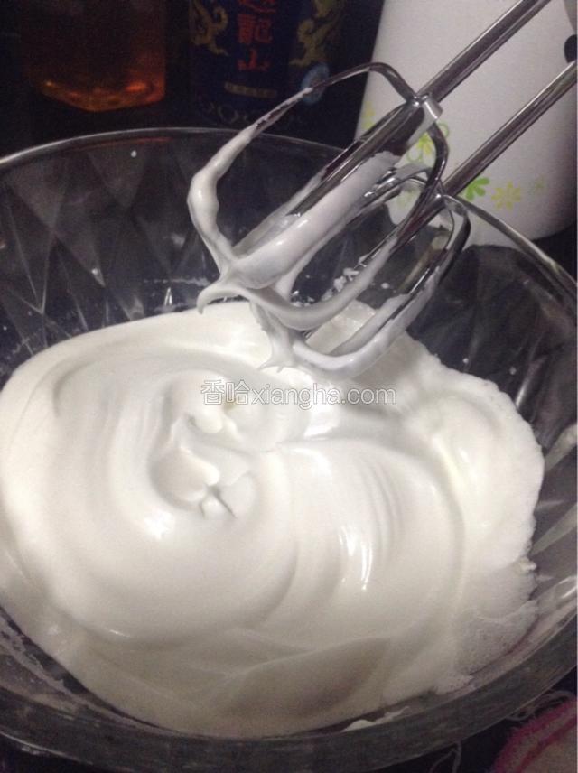再继续搅拌至湿性发泡。提起打蛋器可见弯弯的尖角