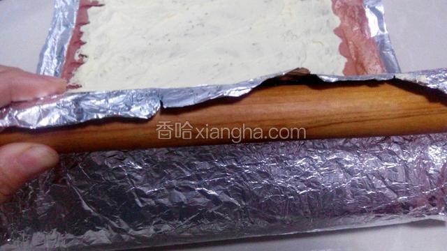 把擀面杖反方向卷到锡纸上，卷擀面杖的同时推动蛋糕卷起来。