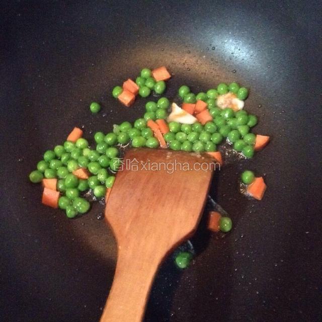 锅中放少许油放入青豆和胡萝卜煸炒。