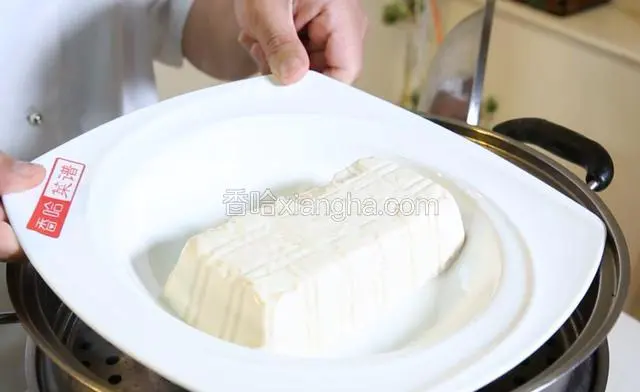 嫩脂豆腐码入盘中，蒸锅上汽，放入豆腐蒸20分钟。