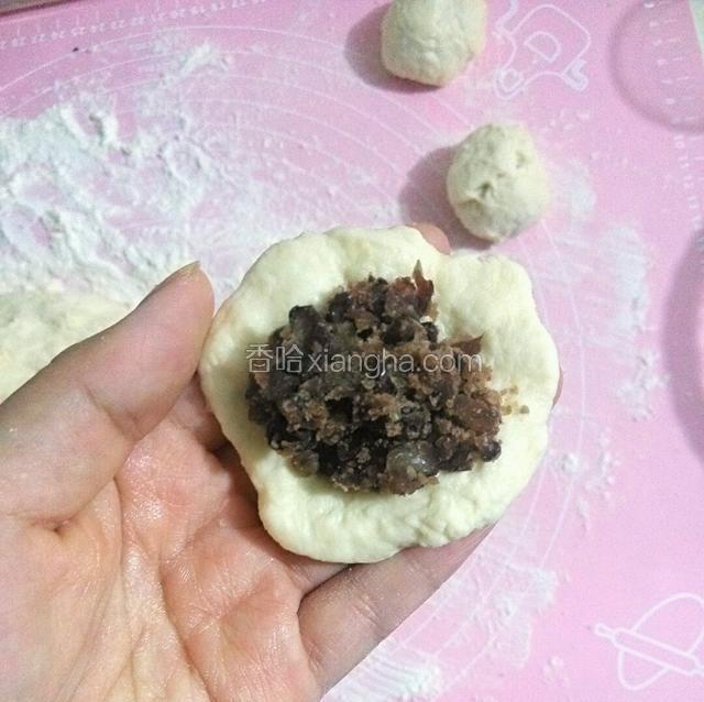 把面团分成小团，先用手粘点花生油，在把面团捏圆压煸，这样就不粘手了，加入红豆馅