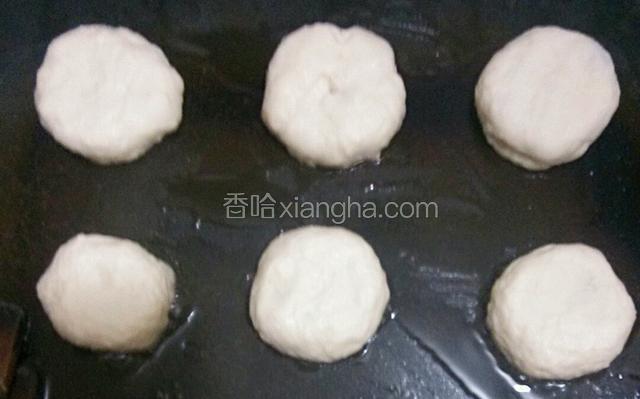 在煎锅中刷入花生油，把包好的饼收口朝下用手稍微压煸，