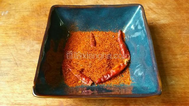 取一耐热的碗，放入辣椒粉和适量红干椒。