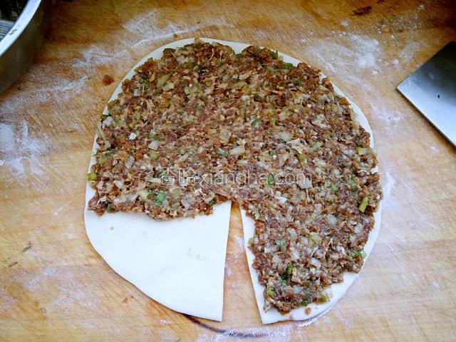 然后放入羊肉馅，留一角不放肉馅