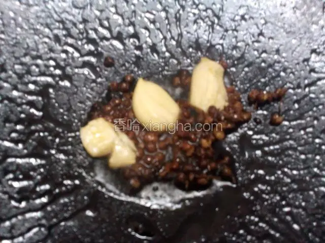油锅烧热，放入蒜头和花椒，爆出香味。