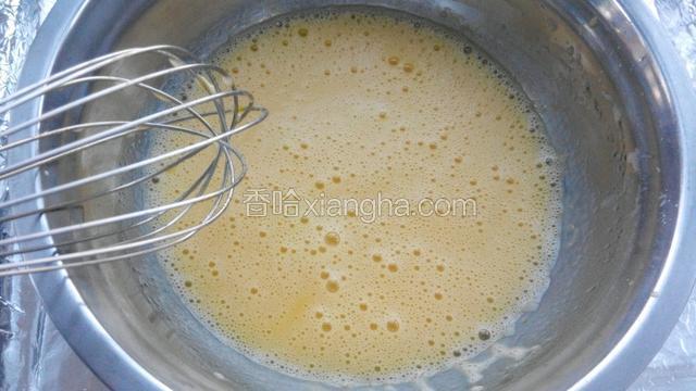 蛋黄打散后加入玉米油，牛奶和糖搅打均匀。