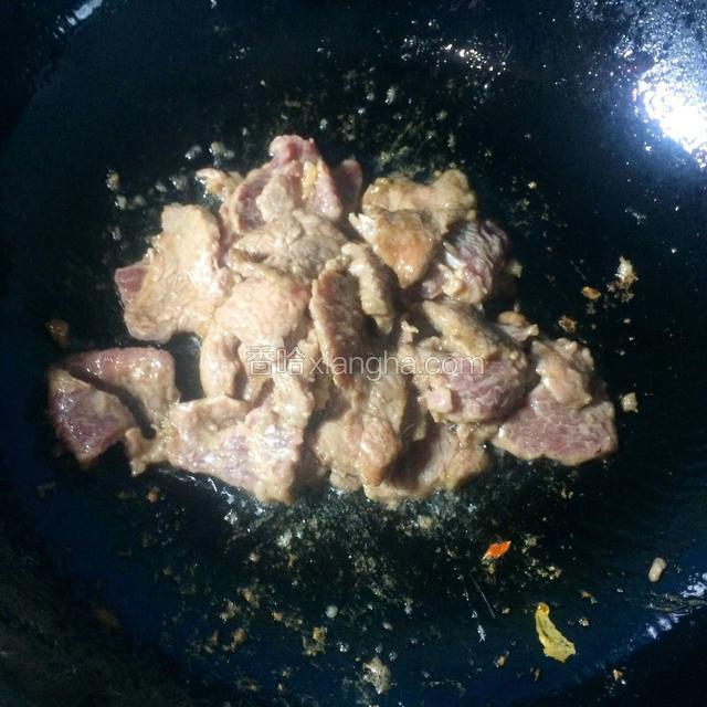 锅内放适量的油（可以多放点），烧热。将腌制好的牛肉下油锅滑至八成熟。