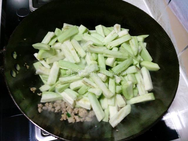 肉馅炒至变白时放入茄子。