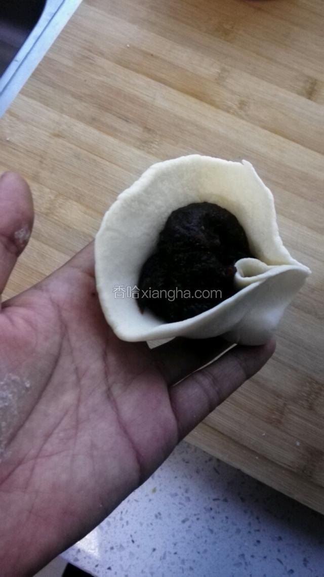 把豆沙馅裹在面皮里，包成包子
