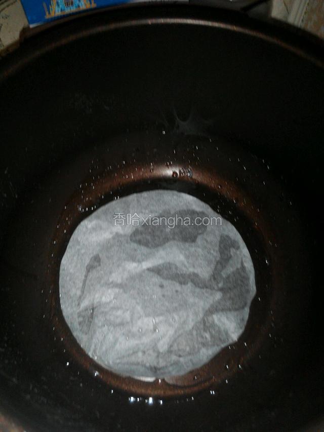 把拌好的蛋黄蛋白放一边，把电饭锅先保温一下，然后加点花生油，放上一张白纸