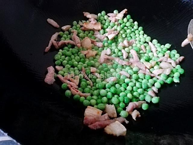 再把豌豆倒下去不停的炒1分钟左右