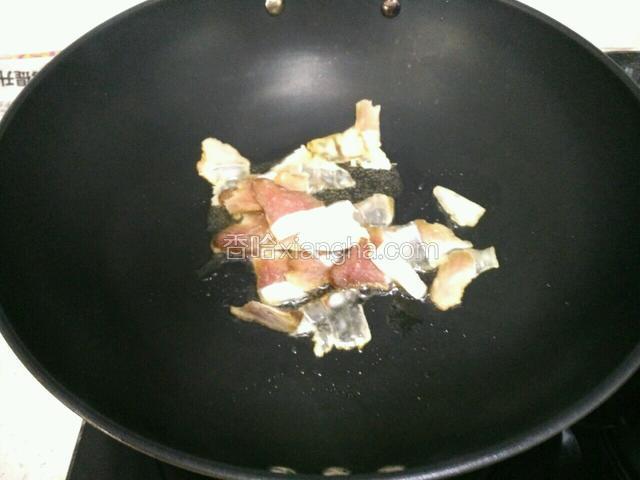 锅里放少许油烧热，倒入腊肉炸至吐油。
