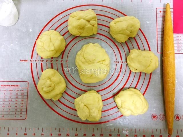 把面团拿出排气，我用擀面杖把面团反复擀压来进行排气。把面团分成一个大面团，七个小面团，盖上保鲜膜松弛15分钟。
