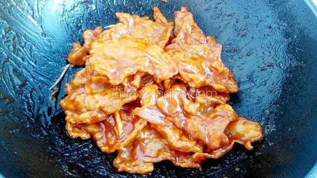 倒入炸好的肉片快速翻炒，使每片肉都裹上酱汁。