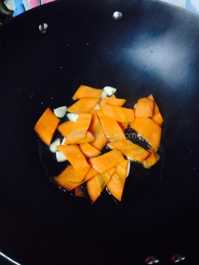 开小火，锅里倒入少许油，等油温高了加入大蒜和胡萝卜