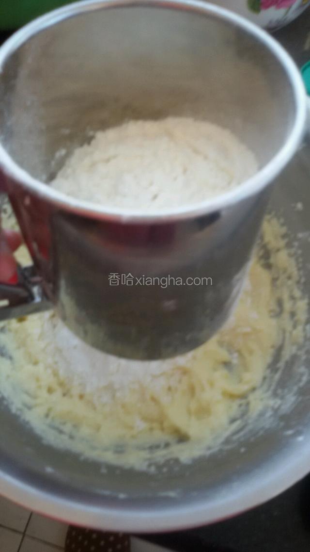 把低筋面粉和泡打粉一起混合好，过筛入打发的黄油鸡蛋液里。