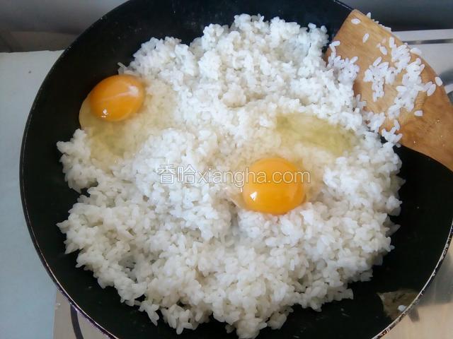在炒好的饭粒里打入2个鸡蛋，继续翻炒